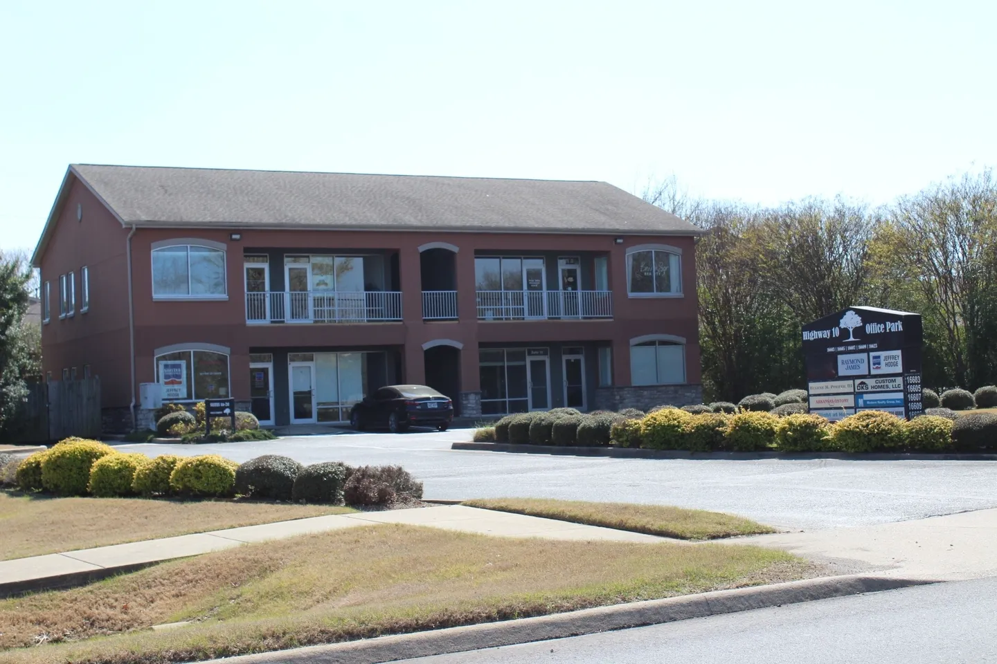 A large brick building with many windows and bushes.