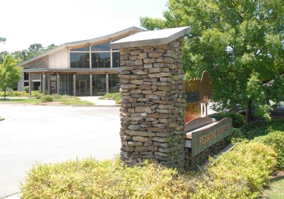 A stone pillar in front of a building.